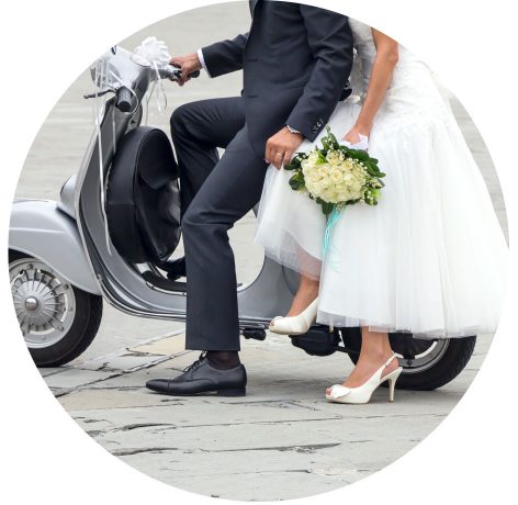 Young newlywed just married, posing on an old gray scooter
